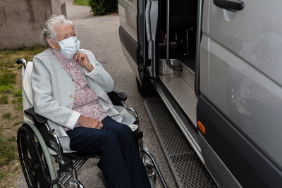 elderly woman in wheelchair beside the open van